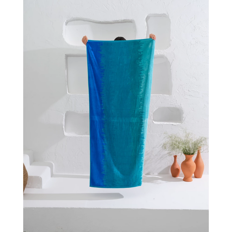 Add a pop of color to your beach day with our organic beach towel in a stylish ombré cold design.